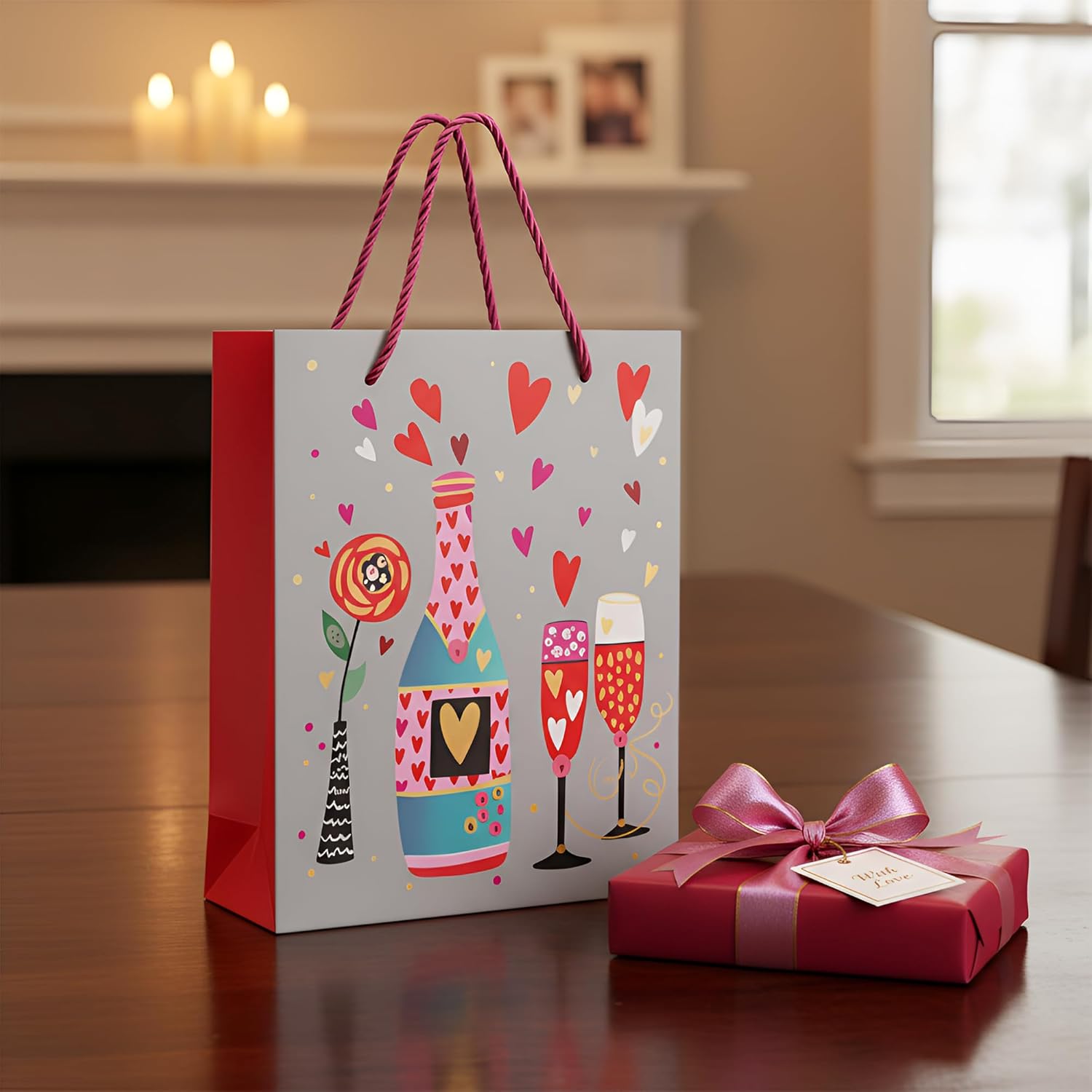 Decorative gift bag with heart designs and a matching gift box on a wooden surface.